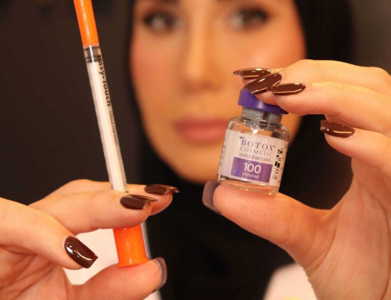 Person holding a syringe and a vial labeled Botox Cosmetic 100 units.
