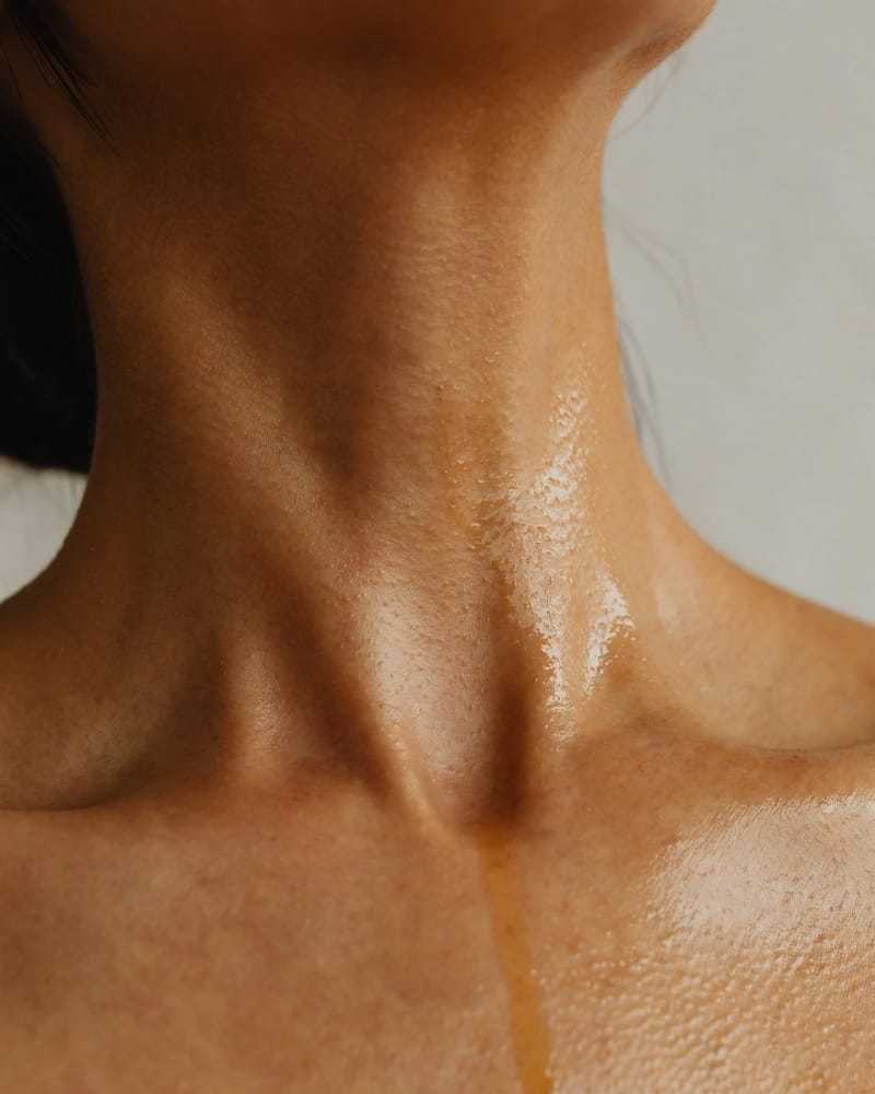 Smooth, glistening skin on a person's neck showing hydration and care.